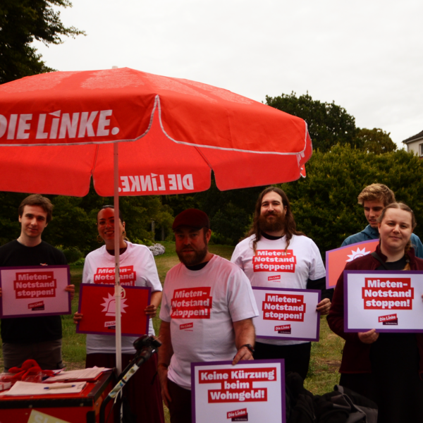 2026_08_18_Mieten-Notstands-Tour_Kiel10q Gruppe mit MdB Tamara Mazzi, Ratsherr Björn Thoroe, Landessprecher Gerrit Schienke, Kreissprecherin Johanna Klitzschmüller und weiteren Genoss*innen mit Schildern gegen den Mieten-Notstand am Aktionsstand